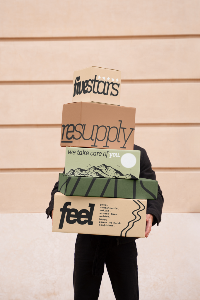 A person holding several resupply boxes of medical equipment.