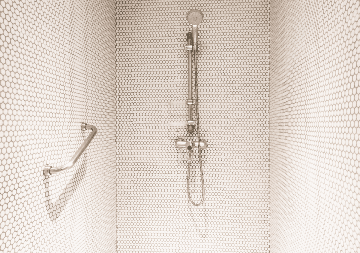 Accessible shower with grab bar and handheld showerhead for safe bathing in small bathrooms