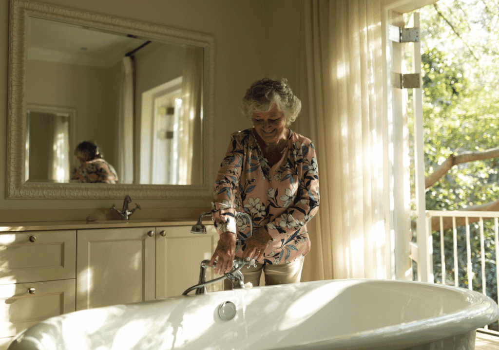 Smiling senior woman preparing bath safely in a sunlit bathroom